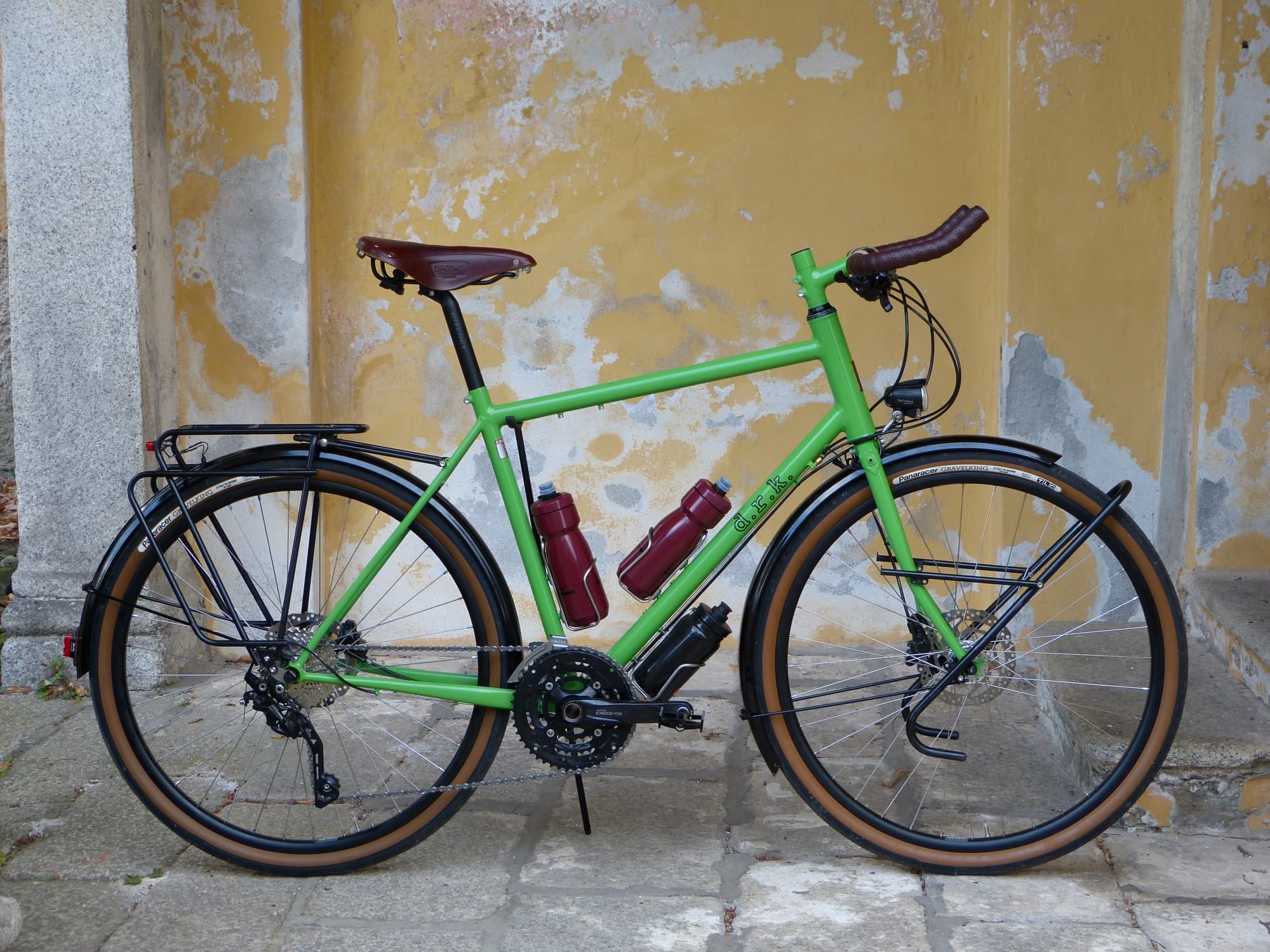 custom hand-made green bicycicle with several mounting points for racks and bottles