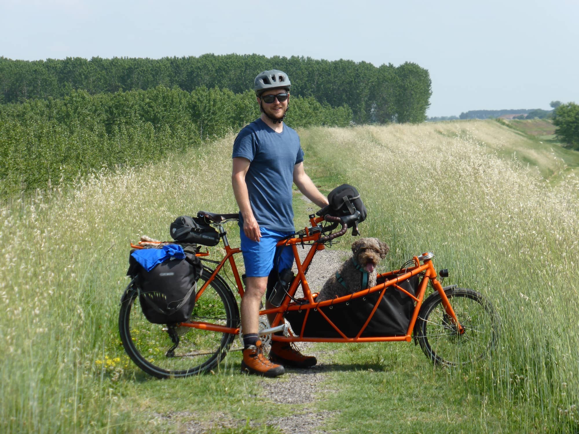 orange cargo bike on a path with Daniel and Zola