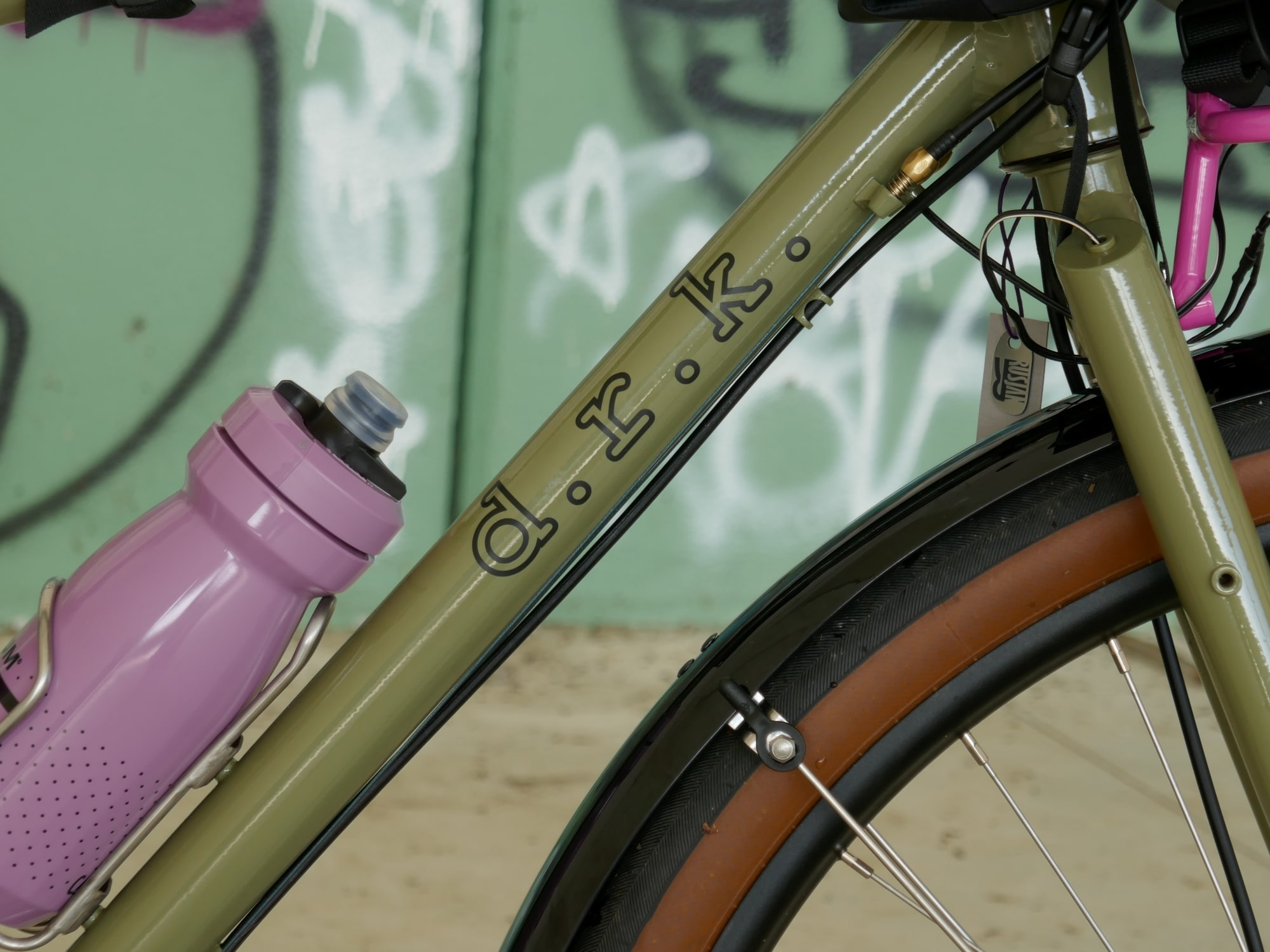 detail of green gravel bike with pink water bottle