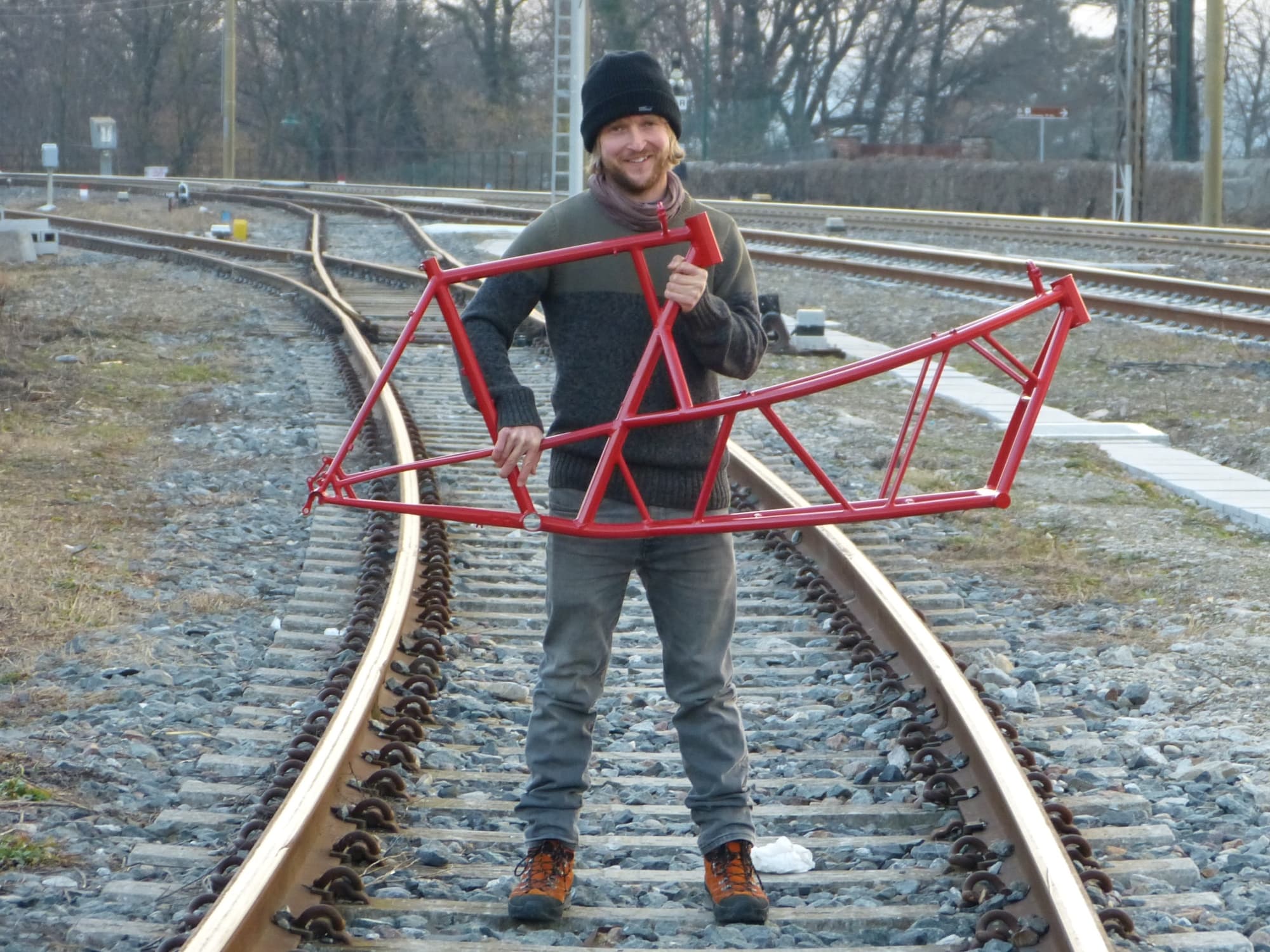 Daniel holding a red cargo bike frame