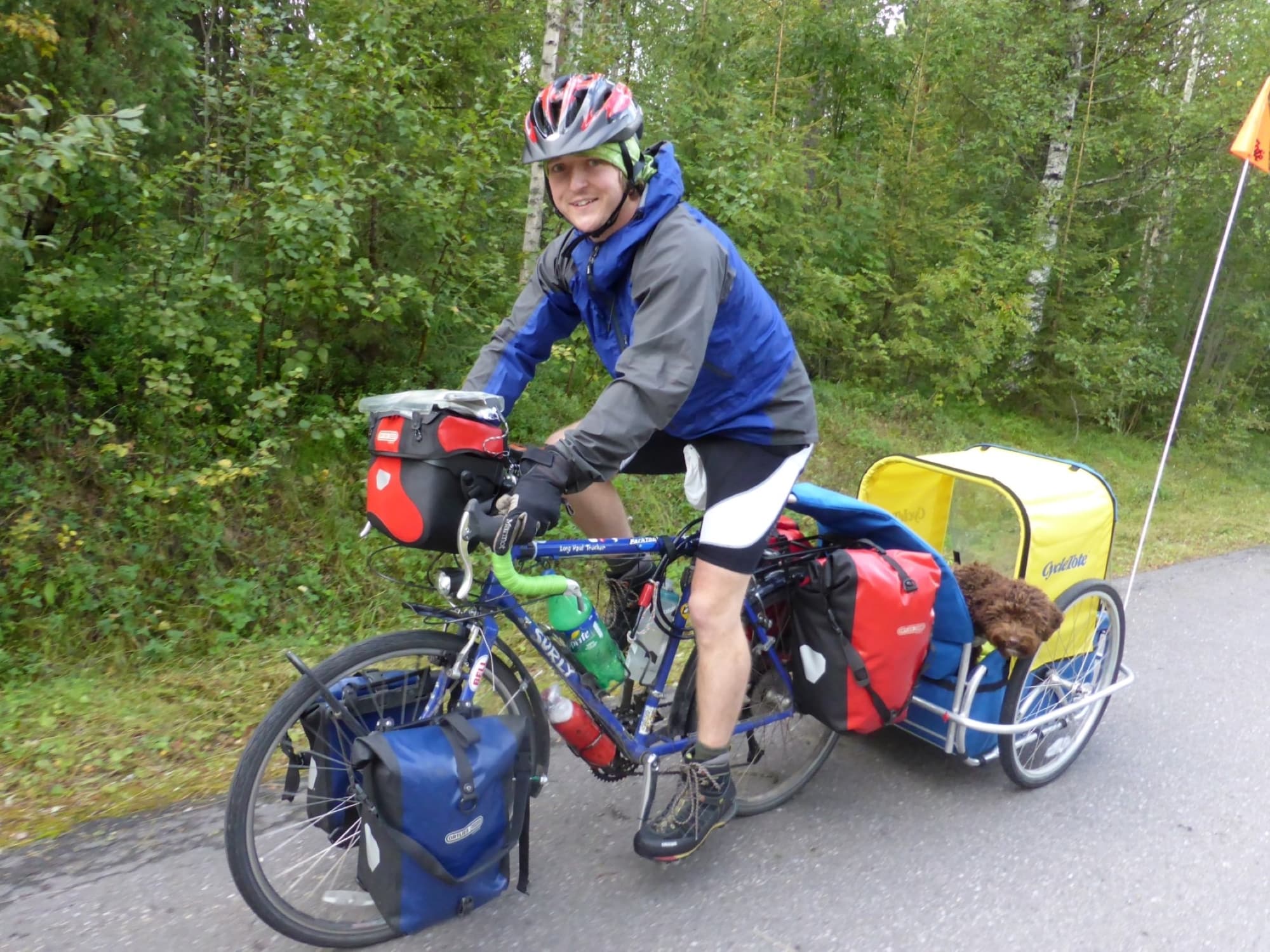 Daniel cyciling with puppy Zola in a trailer